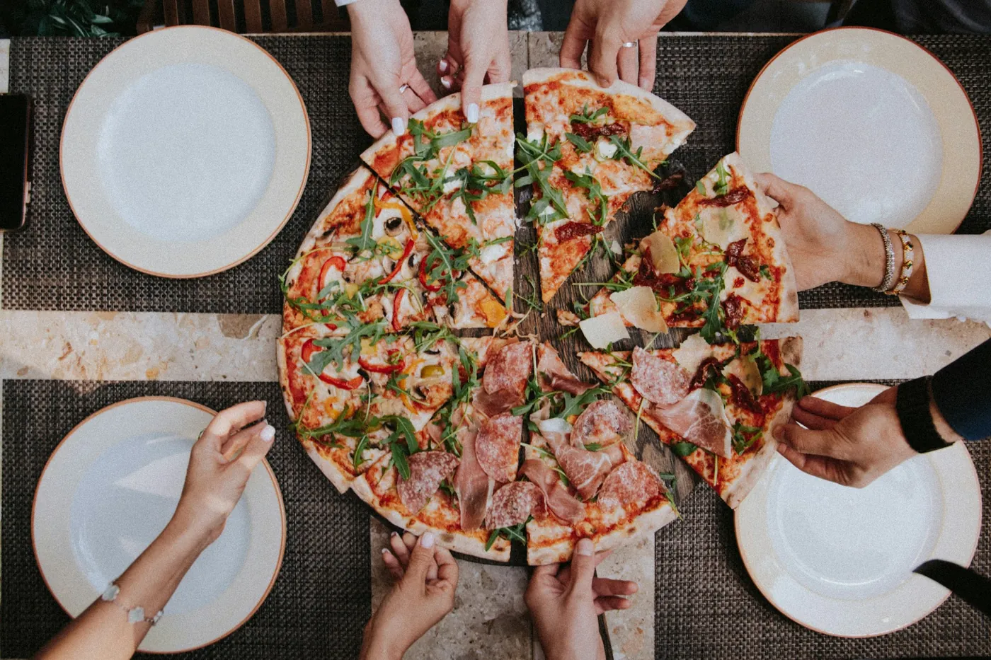 Amigos repartiendo una pizza